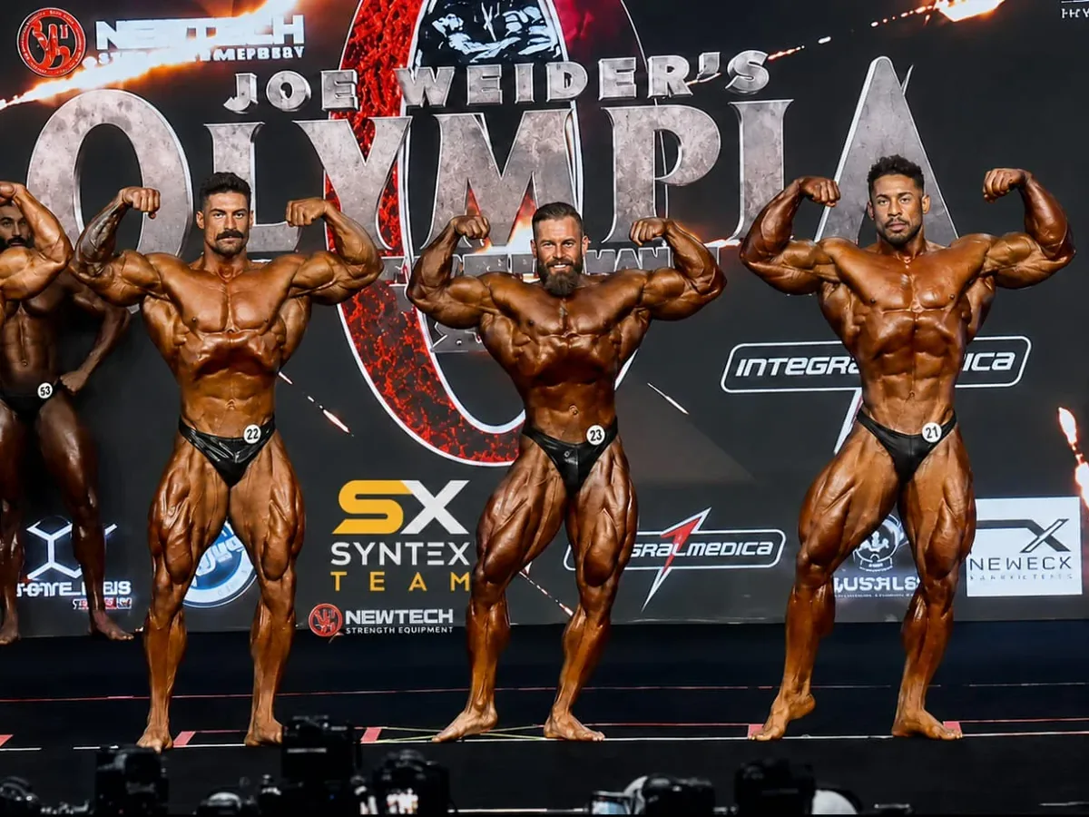 Syntex Team athletes on the Olympia stage under the Syntex banner