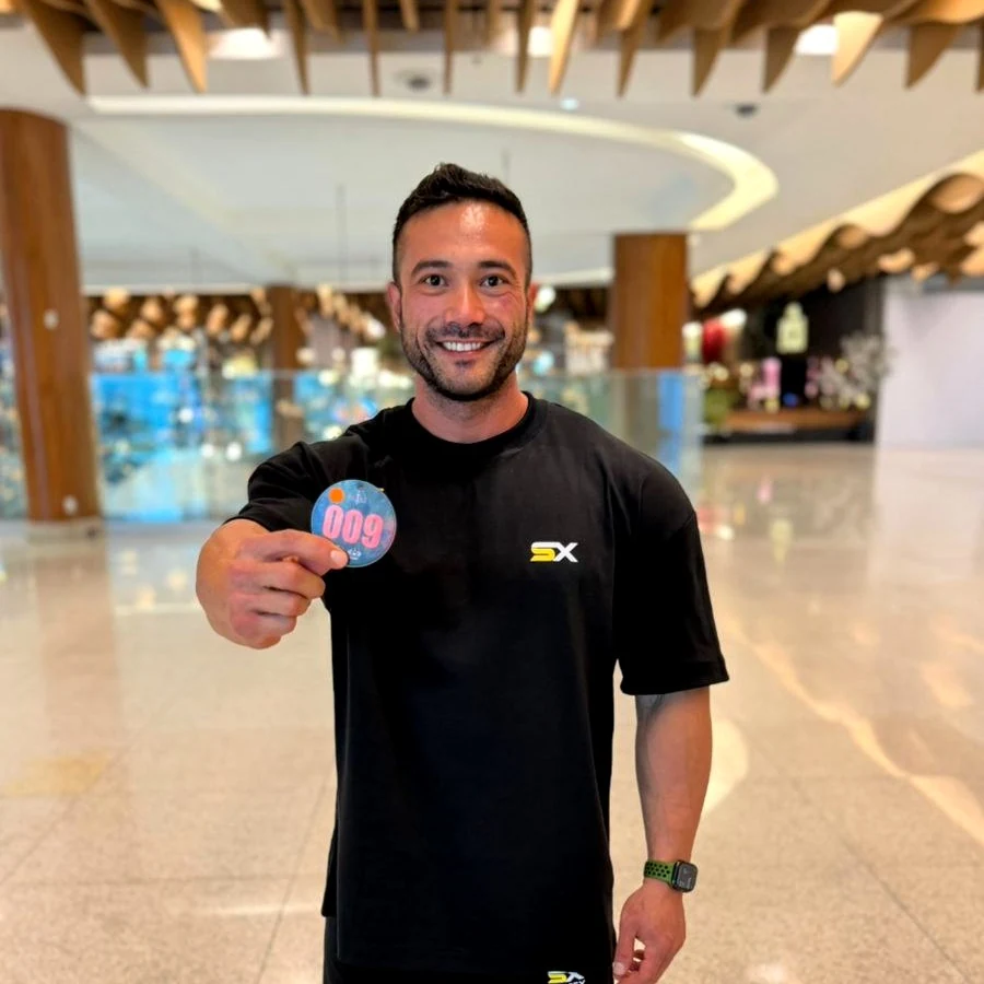 Syntex athlete holding his competition number on registration day